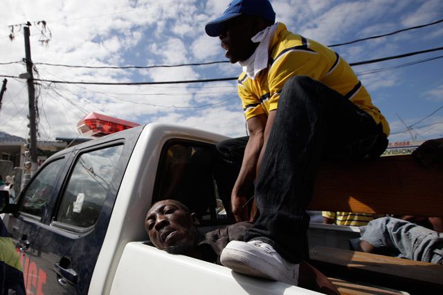 Police guards a detained man accused of trying to steal food in a market in Port-au-Prince.